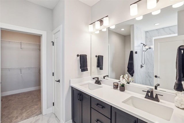 full bathroom featuring a walk in closet, marble finish floor, a sink, and a walk in shower