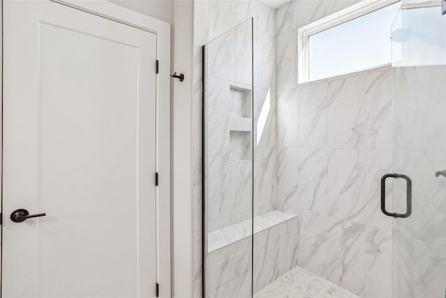 bathroom with a marble finish shower