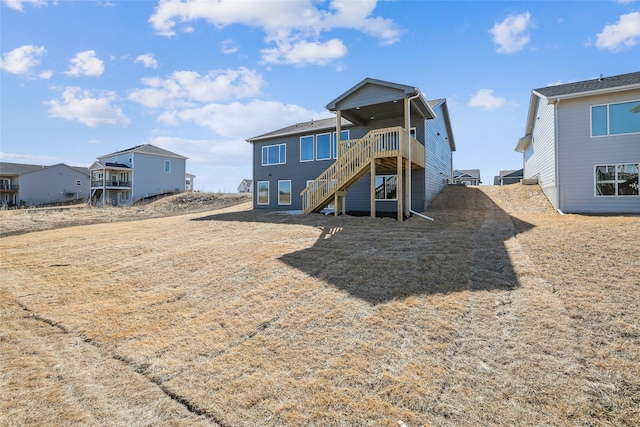 back of property with a wooden deck and stairs