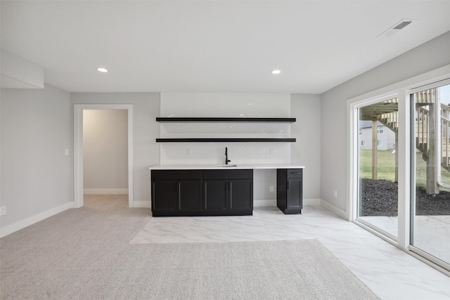 unfurnished living room with recessed lighting, light colored carpet, visible vents, a sink, and baseboards