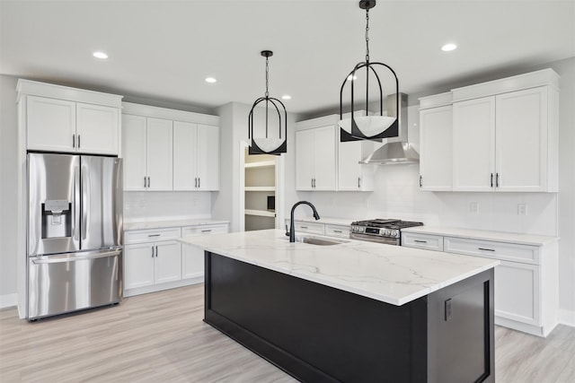 kitchen with white cabinets, wall chimney exhaust hood, stainless steel appliances, and a sink