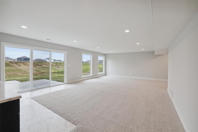 living area with light tile patterned floors, baseboards, light colored carpet, and recessed lighting