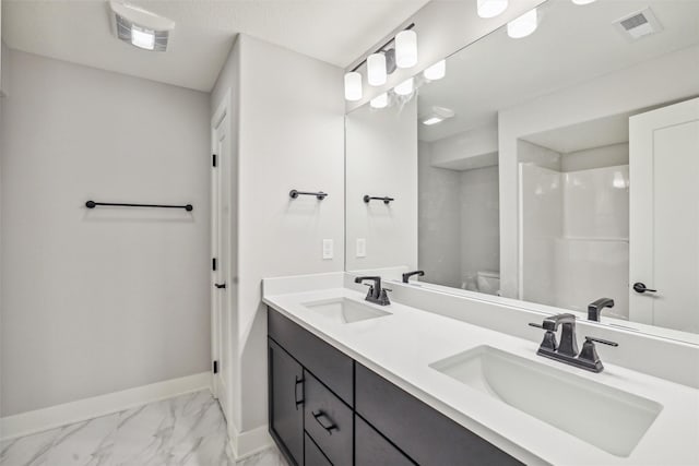 bathroom featuring marble finish floor, a sink, visible vents, and baseboards