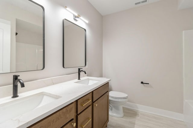 bathroom featuring vanity, walk in shower, and toilet