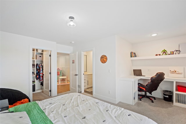 bedroom with a walk in closet, ensuite bathroom, a closet, and light colored carpet