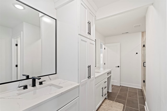 bathroom featuring tile patterned floors, vanity, and a shower with shower door