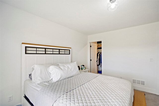 bedroom with carpet flooring, a walk in closet, and a closet