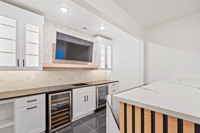 kitchen featuring white cabinets, decorative backsplash, wine cooler, and dark stone countertops