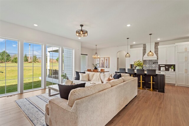 living room with light hardwood / wood-style flooring and an inviting chandelier