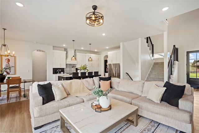 living room with light wood-type flooring and an inviting chandelier