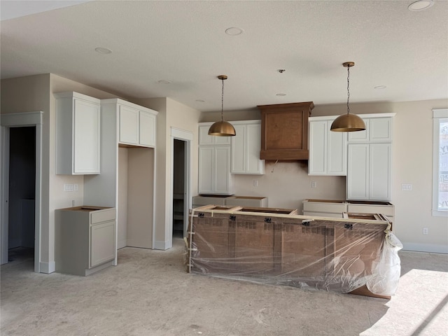 kitchen with pendant lighting, light carpet, and white cabinets