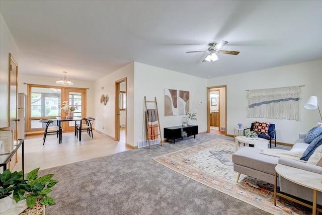 living room featuring light hardwood / wood-style flooring and ceiling fan with notable chandelier