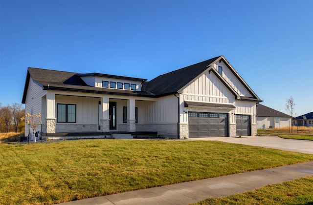 view of front of home featuring a garage, driveway, a front lawn, and board and batten siding