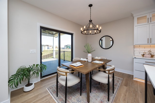 dining space with light hardwood / wood-style flooring and an inviting chandelier