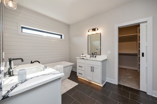 bathroom featuring vanity, a tub to relax in, wood walls, and tile patterned floors