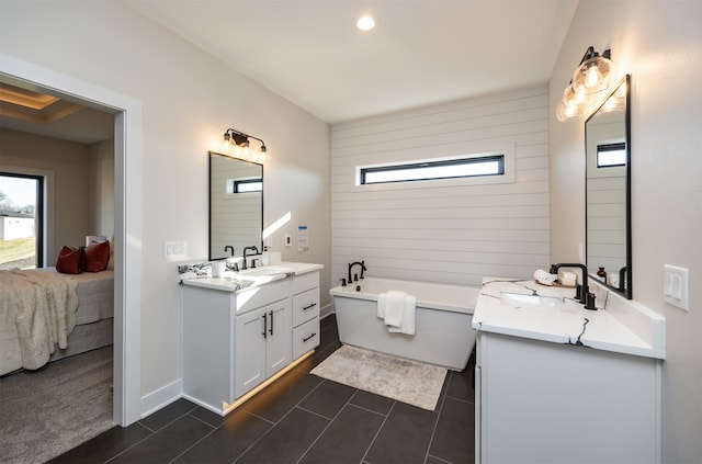 bathroom featuring vanity, a tub to relax in, and tile patterned flooring