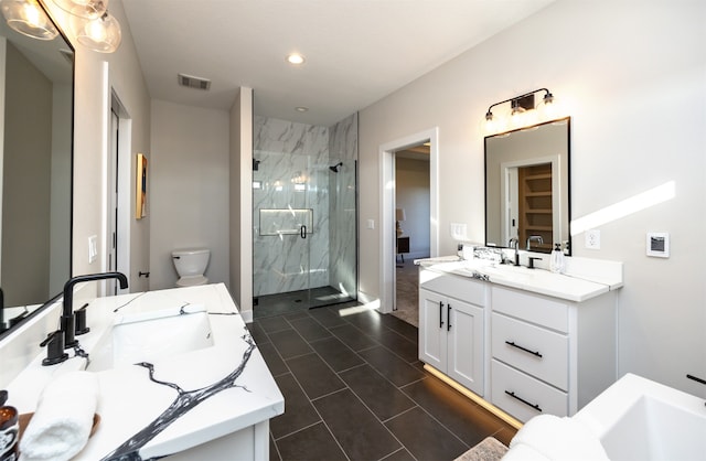 bathroom with a shower with door, vanity, toilet, and tile patterned flooring