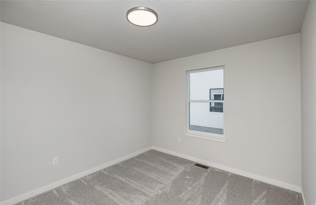 unfurnished room with carpet floors and a textured ceiling