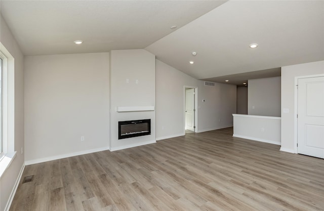 unfurnished living room with lofted ceiling and light hardwood / wood-style flooring