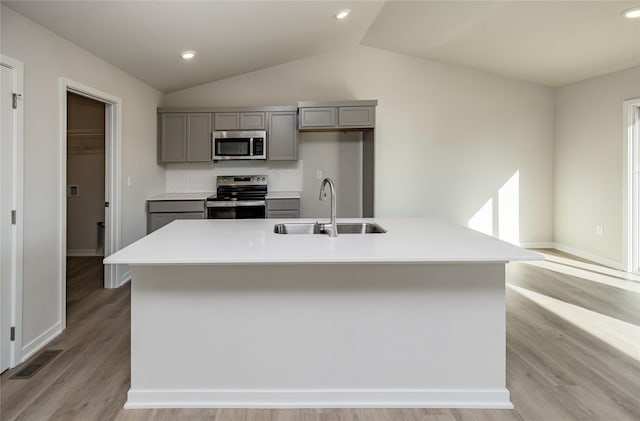 kitchen with sink, backsplash, an island with sink, and appliances with stainless steel finishes