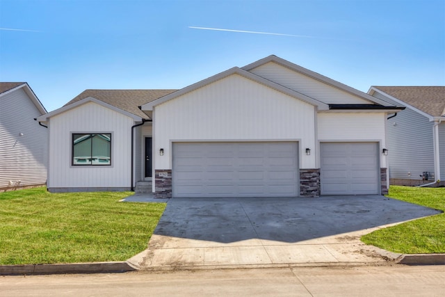 view of front of property with roof with shingles, concrete driveway, an attached garage, a front yard, and stone siding