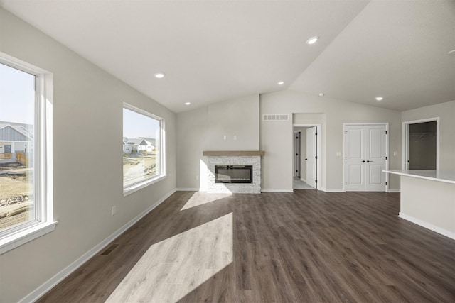 9748 Thorton Dr, Johnston, IA 50131 - unfurnished living room with vaulted ceiling, a stone fireplace, dark wood-style floors, baseboards, and recessed lighting