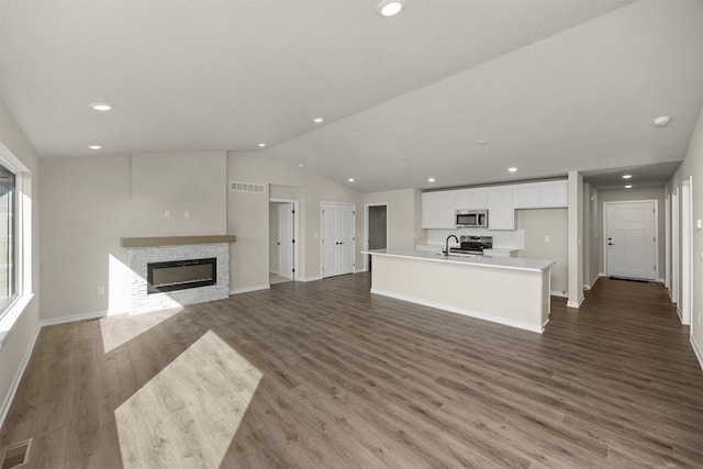 9748 Thorton Dr, Johnston, IA 50131 - unfurnished living room featuring vaulted ceiling, baseboards, recessed lighting, dark wood-style flooring, and a fireplace