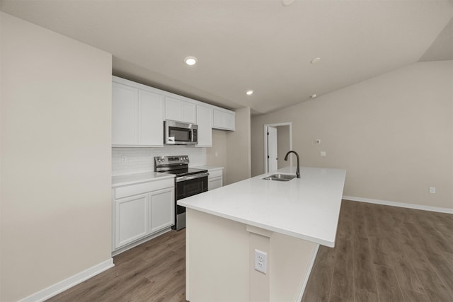 9748 Thorton Dr, Johnston, IA 50131 - kitchen with stainless steel appliances, a sink, lofted ceiling, wood finished floors, and tasteful backsplash