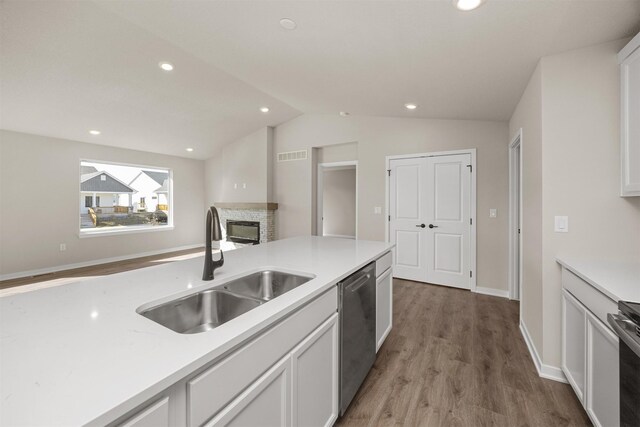 9748 Thorton Dr, Johnston, IA 50131 - kitchen featuring a sink, appliances with stainless steel finishes, light wood-style floors, vaulted ceiling, and white cabinetry