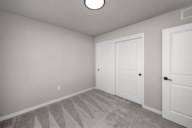 9748 Thorton Dr, Johnston, IA 50131 - unfurnished bedroom featuring carpet flooring, baseboards, a closet, and a textured ceiling