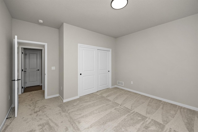 9748 Thorton Dr, Johnston, IA 50131 - unfurnished bedroom featuring light carpet, baseboards, and a closet