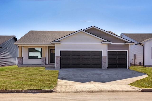 view of front of property with an attached garage, a shingled roof, concrete driveway, and a front yard