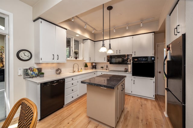 kitchen with white cabinetry, black appliances, and a kitchen island