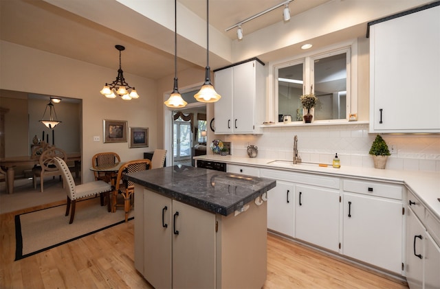 kitchen featuring light hardwood / wood-style floors, decorative backsplash, white cabinetry, and a kitchen island