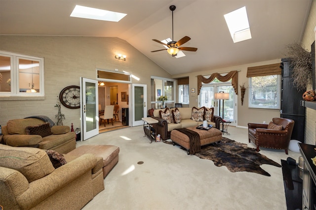 living room featuring french doors, ceiling fan, a skylight, and light colored carpet