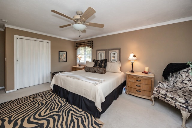 carpeted bedroom with a closet, ornamental molding, and ceiling fan