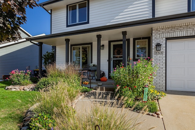 doorway to property featuring covered porch and a garage