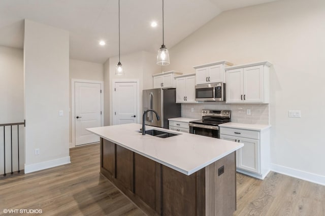 kitchen featuring pendant lighting, appliances with stainless steel finishes, sink, and white cabinets