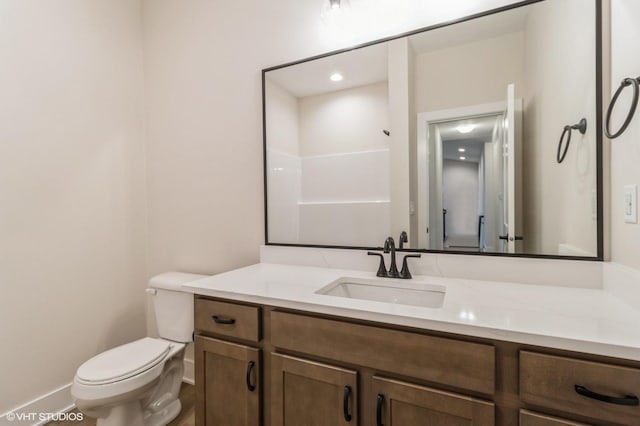 bathroom with vanity, a shower, and toilet