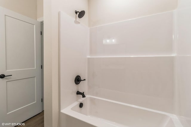 bathroom featuring wood-type flooring and tub / shower combination