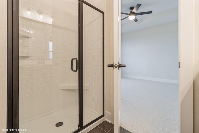 bathroom with tile patterned flooring, ceiling fan, and walk in shower