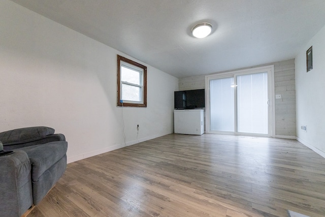 living area with light wood-style flooring and baseboards