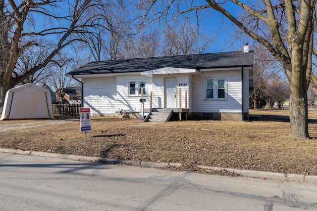 view of front of house with a shingled roof and a chimney