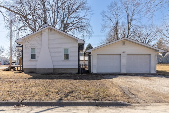 view of side of property with an outbuilding and a detached garage