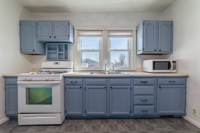 kitchen featuring a sink, baseboards, light countertops, blue cabinetry, and white gas range oven