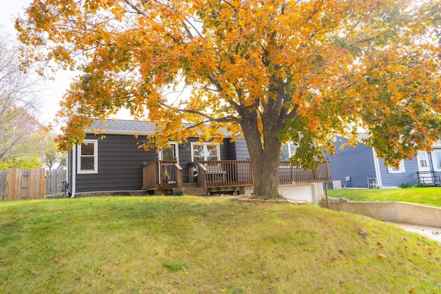 view of front of property with a front yard, a garage, and a wooden deck