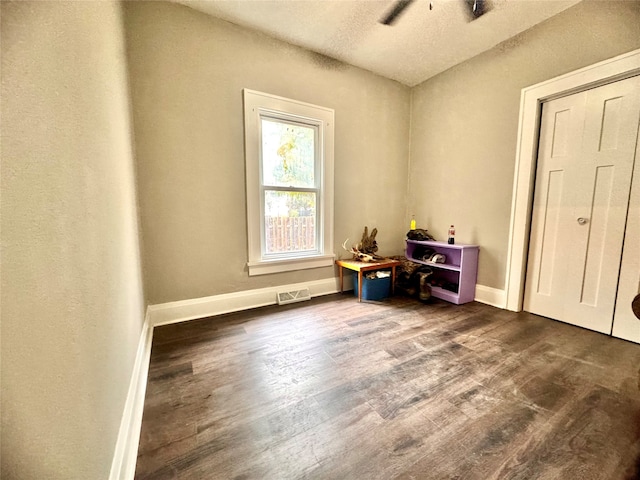 interior space with a textured ceiling and dark hardwood / wood-style flooring