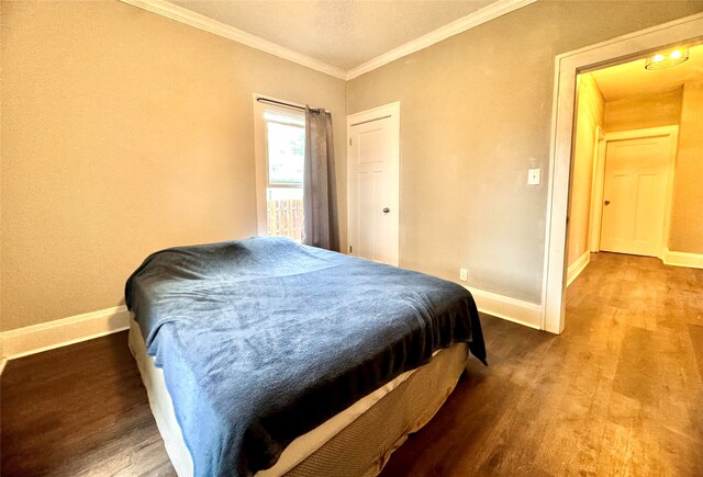 bedroom with crown molding and hardwood / wood-style floors