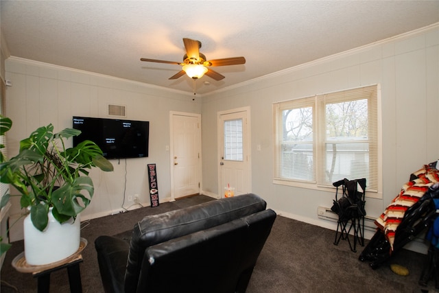 carpeted living room with crown molding, a textured ceiling, and ceiling fan