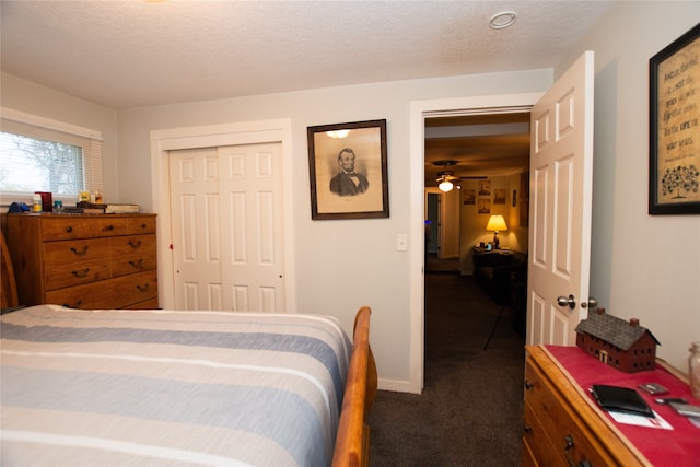 carpeted bedroom with a closet and a textured ceiling